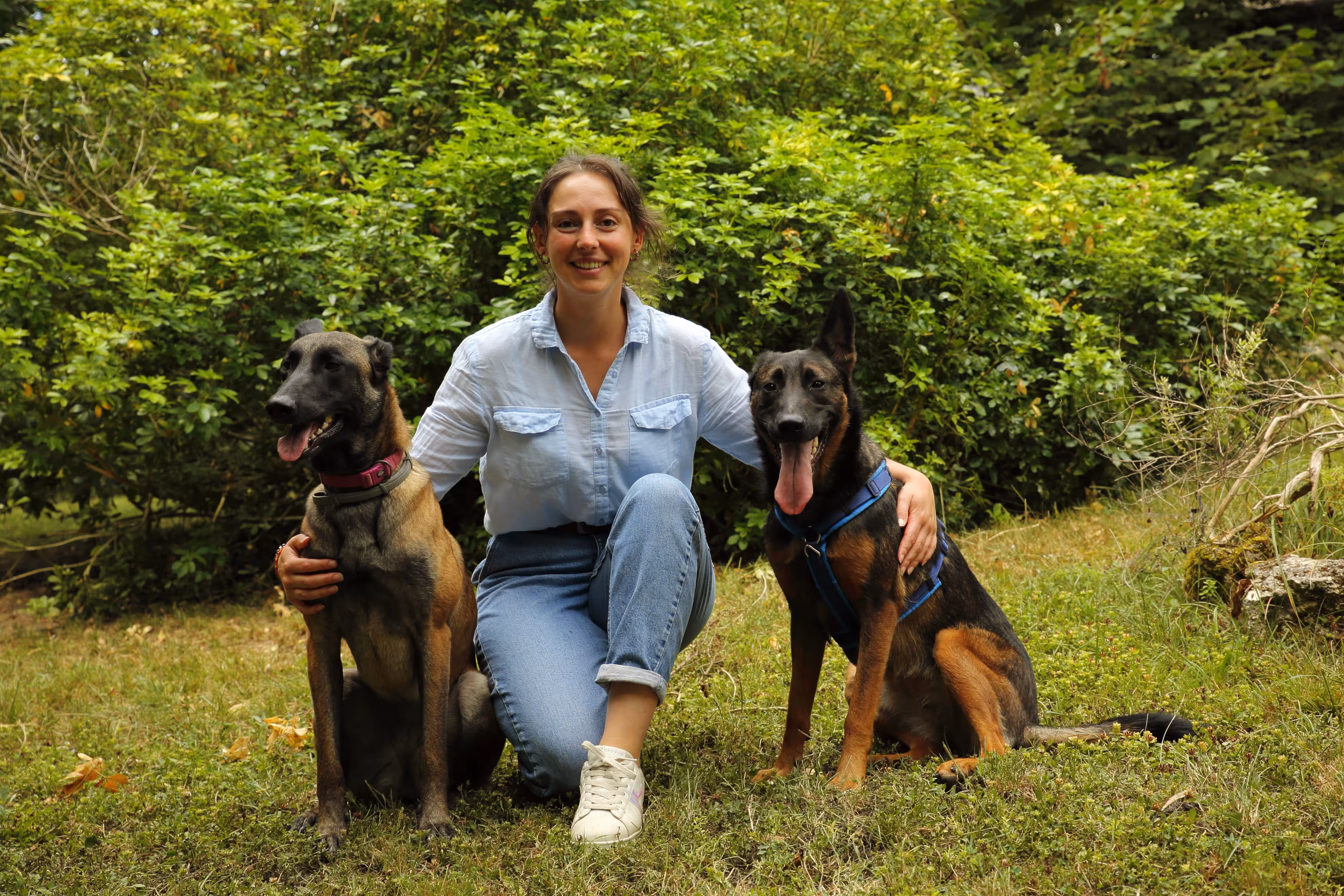 Camille entourée de deux chiens, montrant de l'affection et de la complicité, illustrant son lien avec les animaux